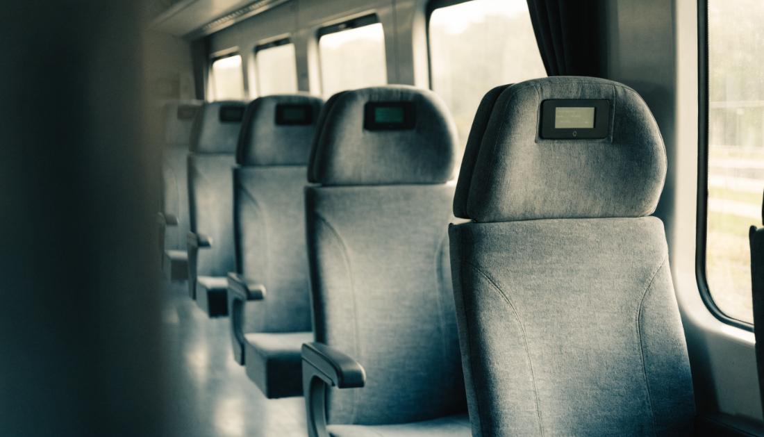 Sitzreihe in einem Fernverkehrszug mit kleinen Anzeigen ueber den Kopfstuetzen