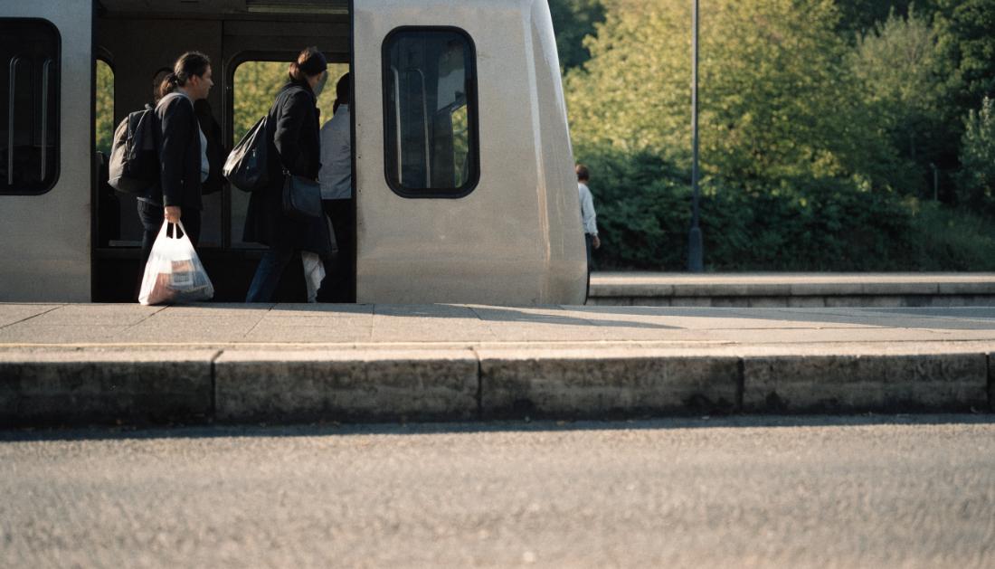 Fahrgaeste steigen an einem kleinen Bahnsteig in einen Regionalzug ein