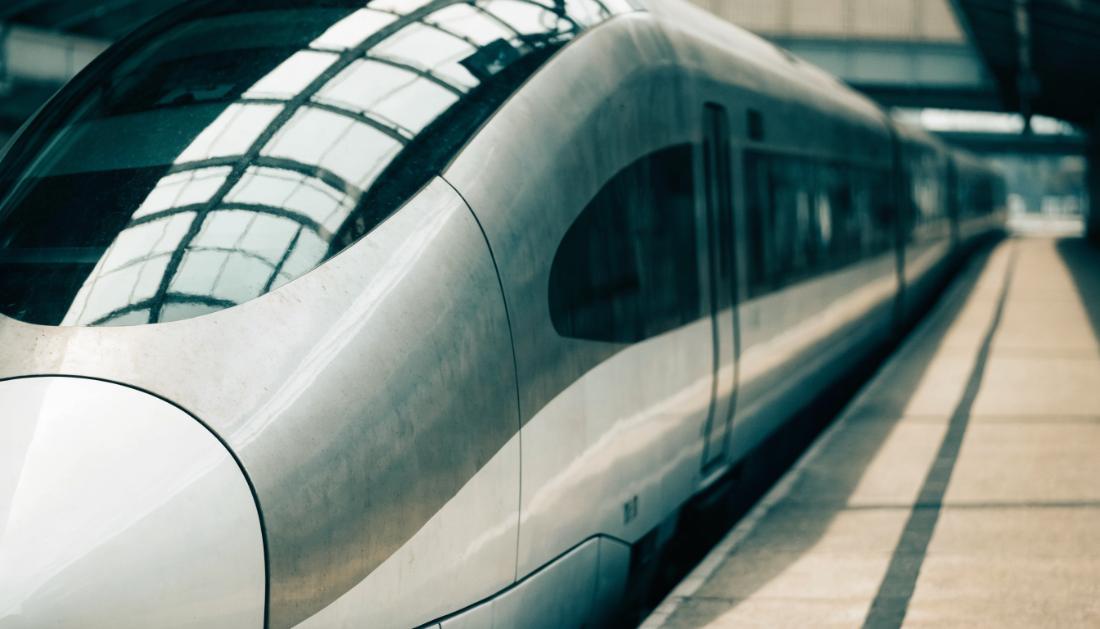 Stromlinienfoermige Front eines weissen Hochgeschwindigkeitszuges am Bahnsteig