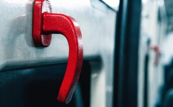 Roter Notbremsgriff an der Innenwand eines Zugwagens