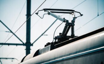 Angehobener Stromabnehmer auf dem Dach eines Zuges liegt am Fahrdraht an