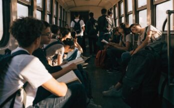 Junge Menschen mit Rucksaecken sitzen in einem vollen Regionalzug