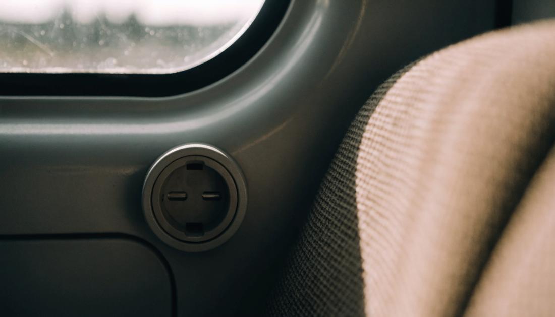 Eine Steckdose in der Seitenverkleidung unter einem Zugfenster