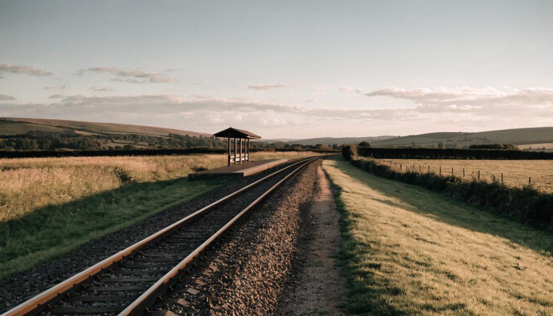 Ein kurzer Bahnsteig mit einfachem Wartehäuschen an einer eingleisigen Strecke