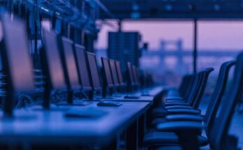 Dunkle Bildschirme und leere Arbeitsplaetze in einer modernen Betriebszentrale