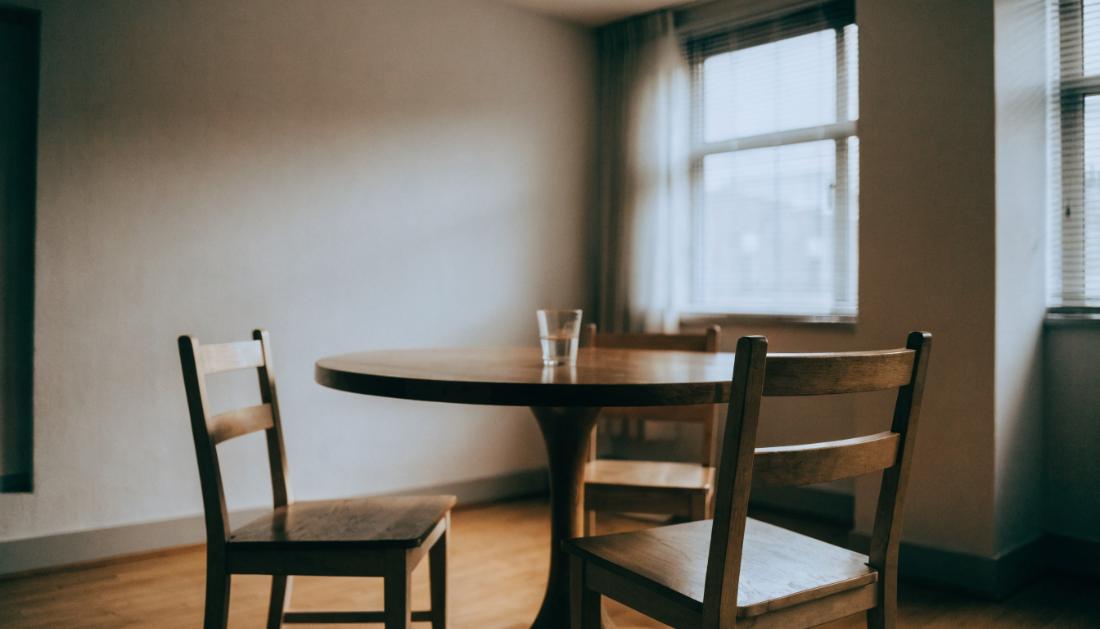 Ein leerer runder Tisch mit drei St&uuml;hlen in einem hellen Besprechungsraum