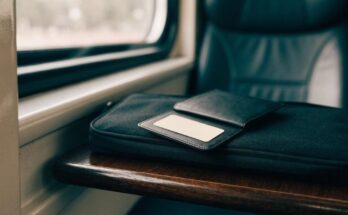 Eine Kartenhuelle mit einer leeren Kundenkarte liegt auf einer Laptoptasche im Zug
