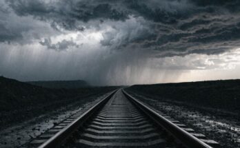 Ein Bahngleis verschwindet in dichten Sturmwolken und Regen