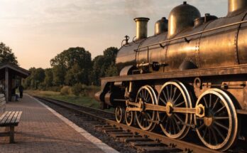 Eine liebevoll restaurierte Dampflokomotive steht an einem kleinen Museumsbahnhof