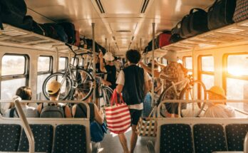 Ein voll besetzter Regionalzug im Sommer mit Fahrgästen und Fahrrädern im Gang