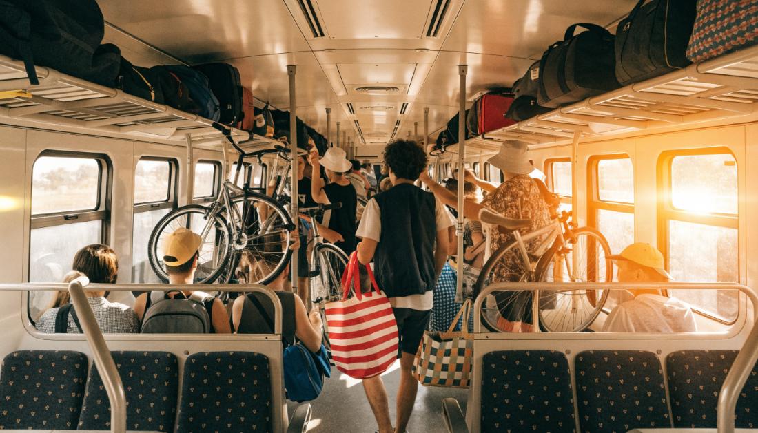 Ein voll besetzter Regionalzug im Sommer mit Fahrgästen und Fahrrädern im Gang