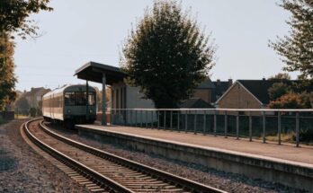 Ein kleiner Vorortbahnsteig mit einem einfahrenden Nahverkehrszug am Nachmittag