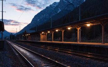 Ein alpiner Grenzbahnhof in der Abenddämmerung mit Bergen im Hintergrund
