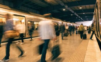Reisende steigen mit Bewegungsunschärfe schnell an einem Bahnsteig in einen Zug ein und aus