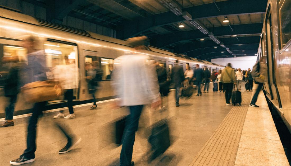 Reisende steigen mit Bewegungsunschärfe schnell an einem Bahnsteig in einen Zug ein und aus