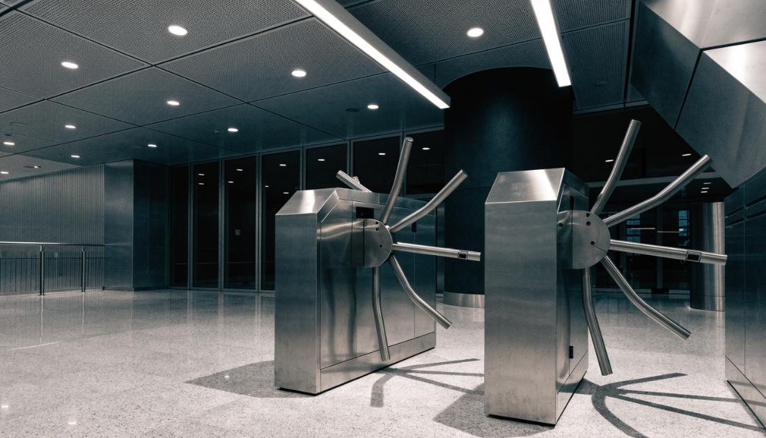Eine moderne Zugangssperre mit Drehkreuzen an einem Bahnhofseingang
