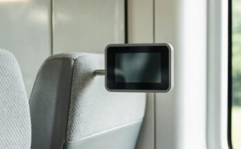 Eine kleine leere digitale Reservierungsanzeige über einem Zugsitz in einem modernen Zuginnenraum