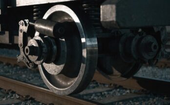 Nahaufnahme eines Zugrads und Bremsmechanismus in dramatischer Seitenbeleuchtung