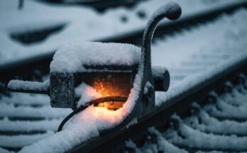 Eine schneebedeckte Weiche mit sichtbarem warmen Schein, der den Schnee ringsherum schmilzt