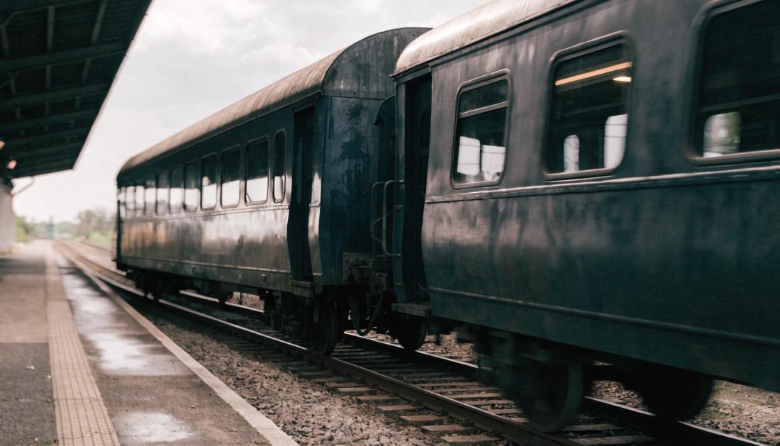 Zwei Eisenbahnwagen werden an einem Bahnsteig getrennt, eine sichtbare Lücke öffnet sich zwischen ihnen