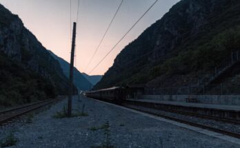 Ein ruhiger Grenzbahnhof in einem Bergtal in der Abenddämmerung mit einem stehenden Zug