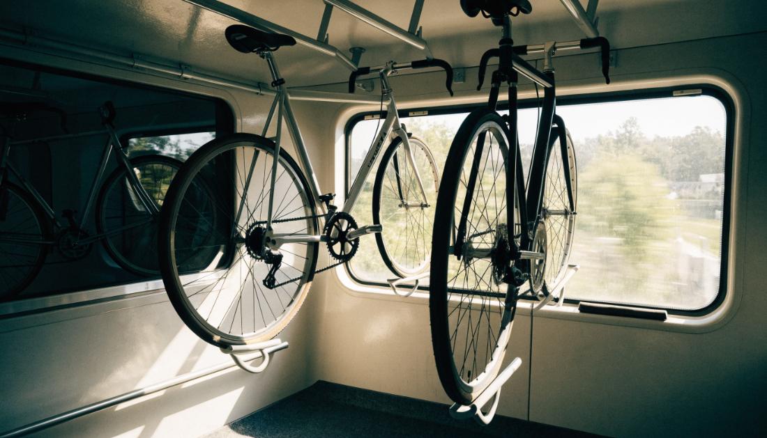 Fahrräder hängen ordentlich in einem eigenen Fahrradabteil in einem Zugwagen