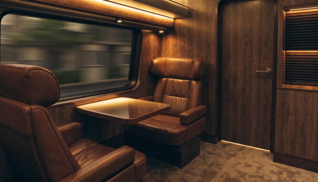 Ein elegantes leeres Erste-Klasse-Abteil mit breiten Sitzen und kleinem Tisch
