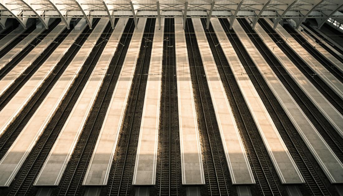 Blick von oben auf viele parallele Bahnsteige und Gleise in einem großen Bahnhof