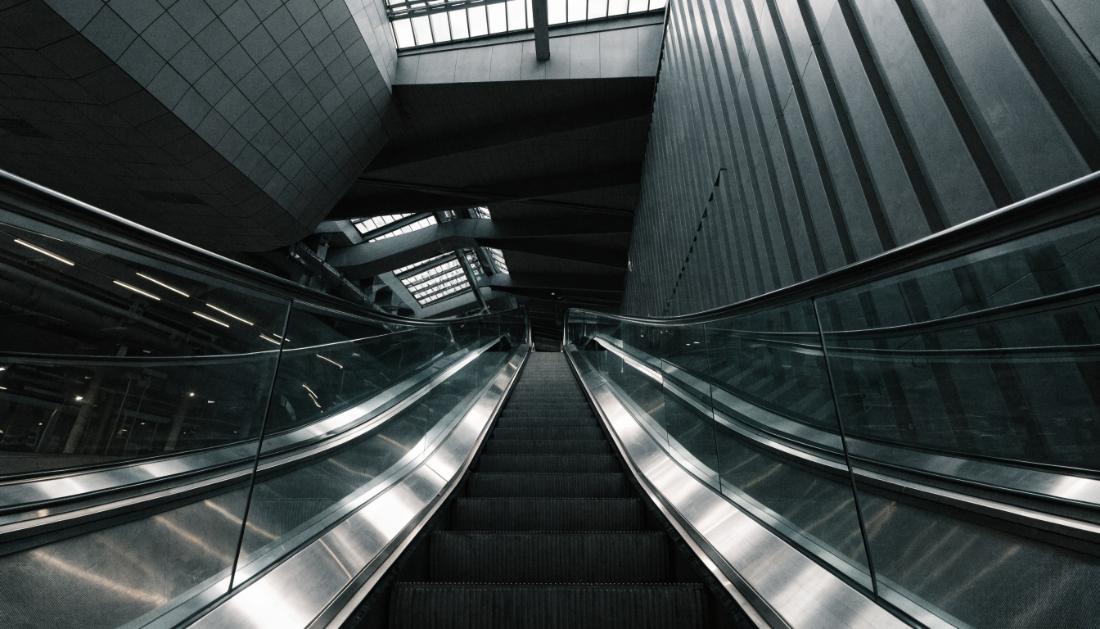 Eine lange Rolltreppe in einem modernen Bahnhof von unten fotografiert