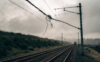 Ein beschädigter Oberleitungsdraht hängt lose über Bahngleisen