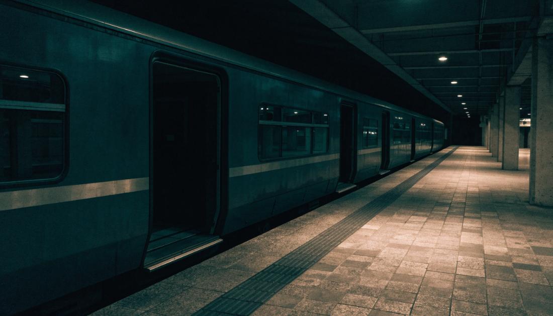 Ein stehender Zug am Bahnsteig mit geöffneten Türen und ausgeschaltetem Innenlicht