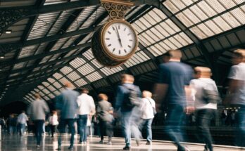 Eine große Bahnhofsuhr über einem belebten Bahnsteig