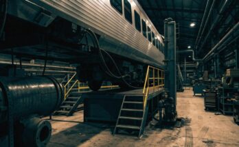Das Innere einer großen Bahnwerkstatt mit einem Zug auf einer Wartungsbühne