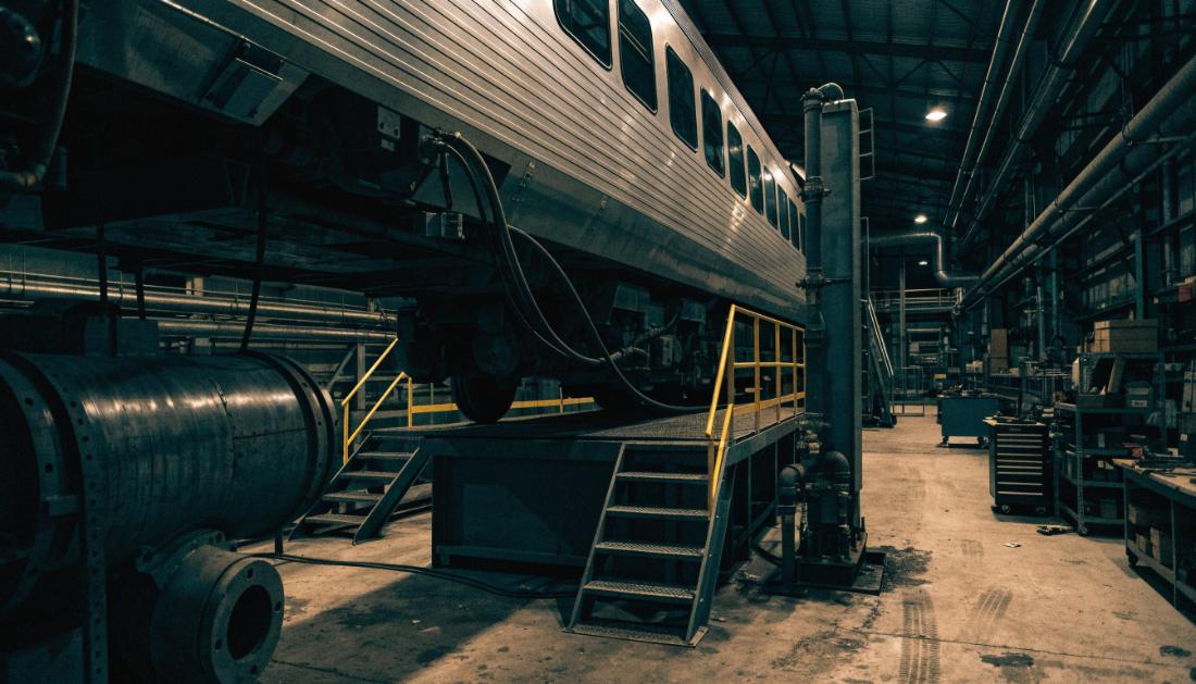 Das Innere einer großen Bahnwerkstatt mit einem Zug auf einer Wartungsbühne