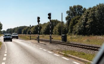 Ein Bahnübergang, an dem eine Straße mit Autos auf eine Bahnstrecke trifft