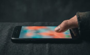 TikTok für Slammer beginnt am Daumen: eine Hand scrollt über ein leuchtendes Display