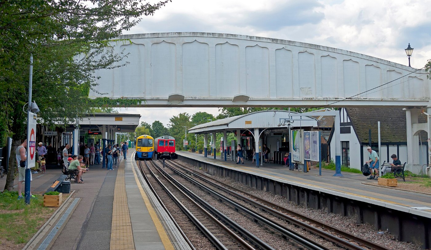 London Overground and Underground trains at Kew Gardens, with footbridge