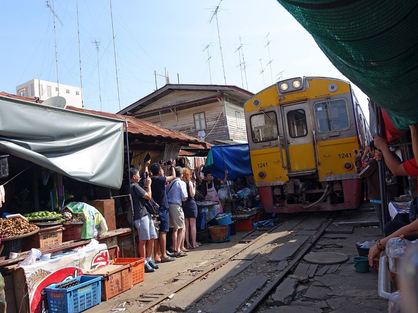 Train passing through Maeklong Railway Market (public domain)