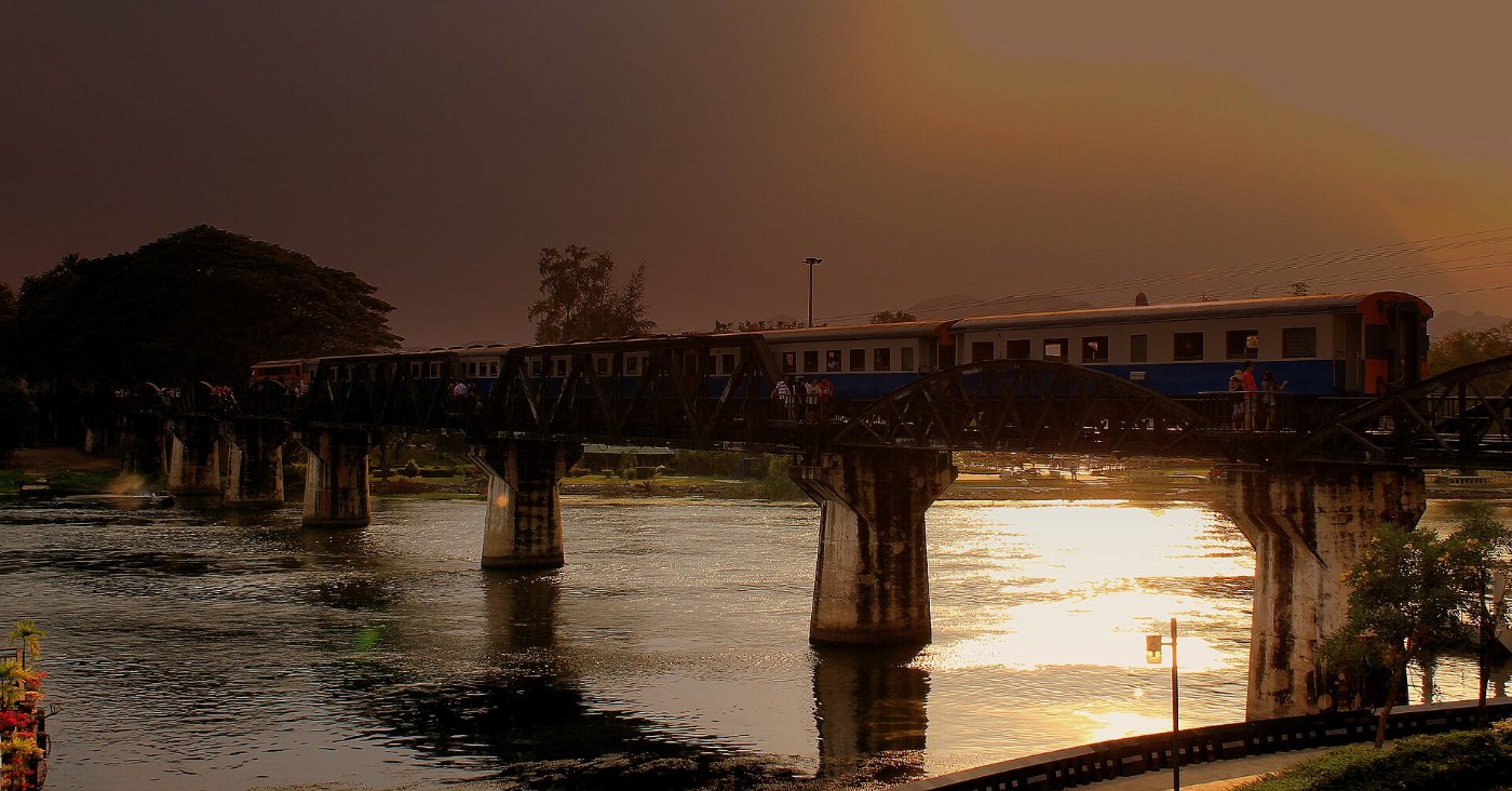 THAI RAILWAYS KRUPPS HAULED TRAIN CROSSES THE RIVER KWAI BRIDGE AT KANCH