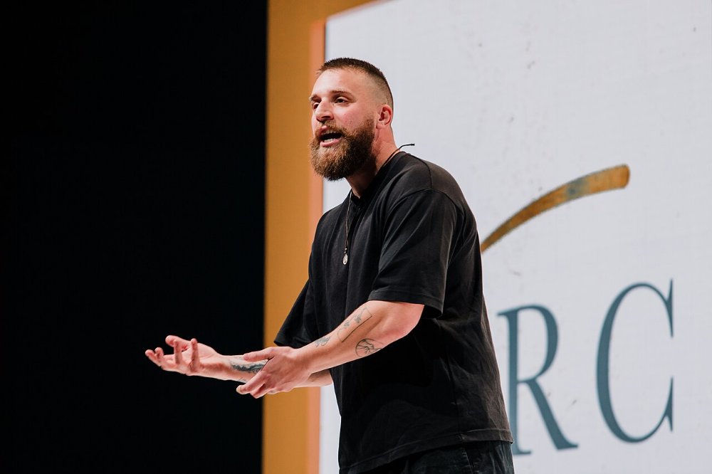 Künstler trägt Spoken Word mit ausdrucksstarker Geste auf einer Bühne vor