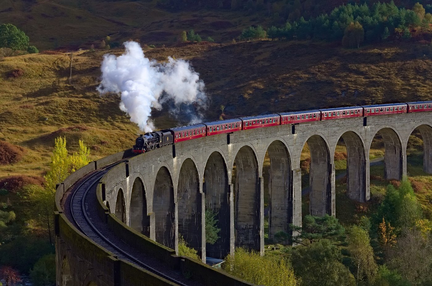 Dampfzug auf dem geschwungenen Glenfinnan-Viadukt in Schottland