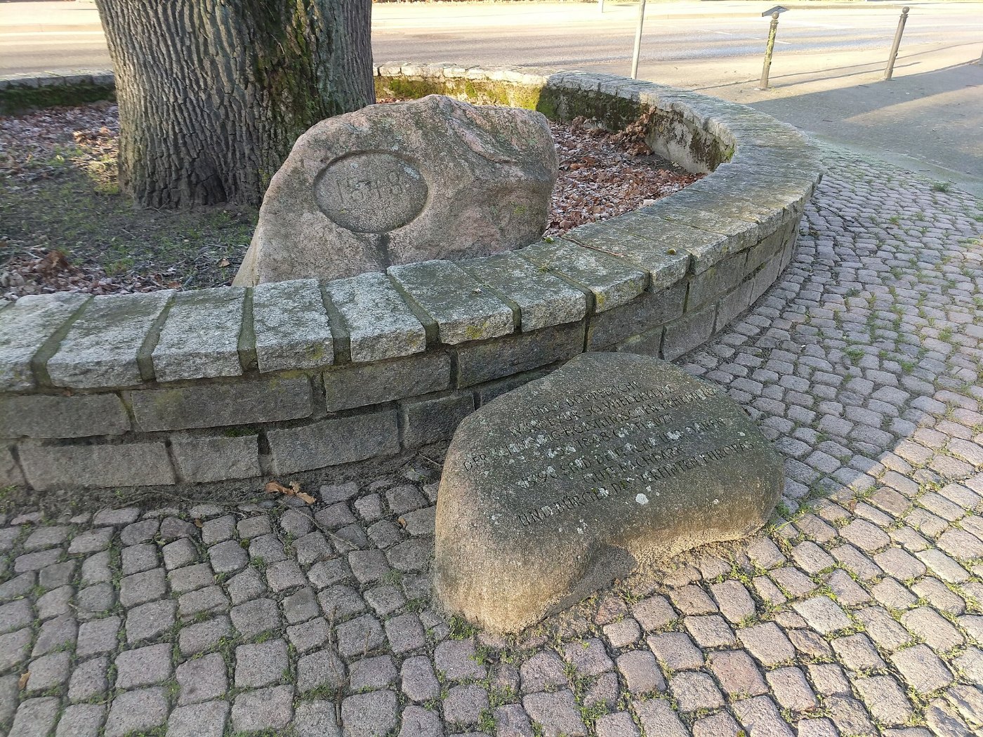 Gedenkstein an Doppeleiche vor dem Preetzer Bahnhof und Stein mit Erklär