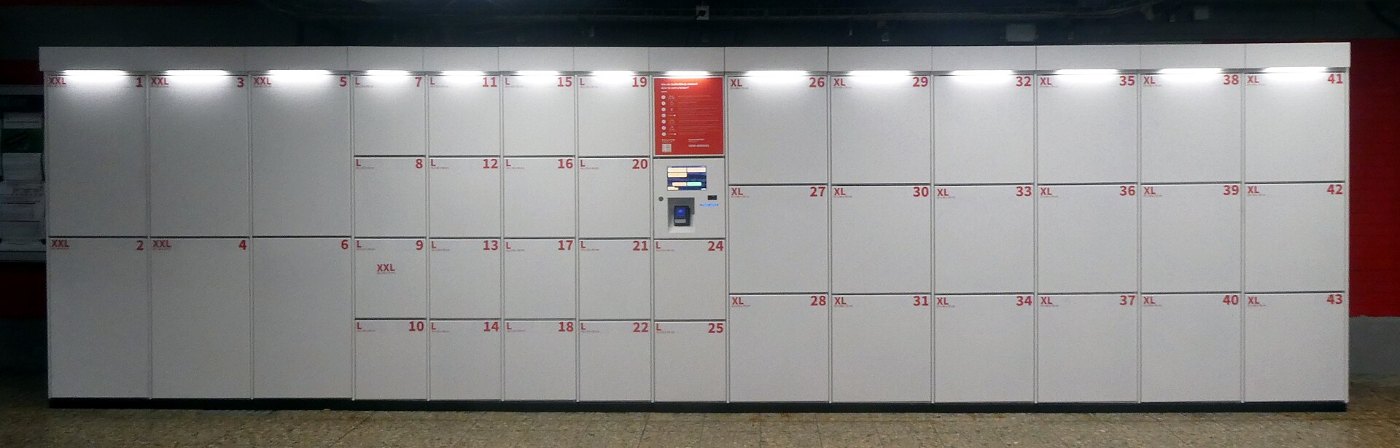 Reisende mit Gepäck in einer Bahnhofshalle