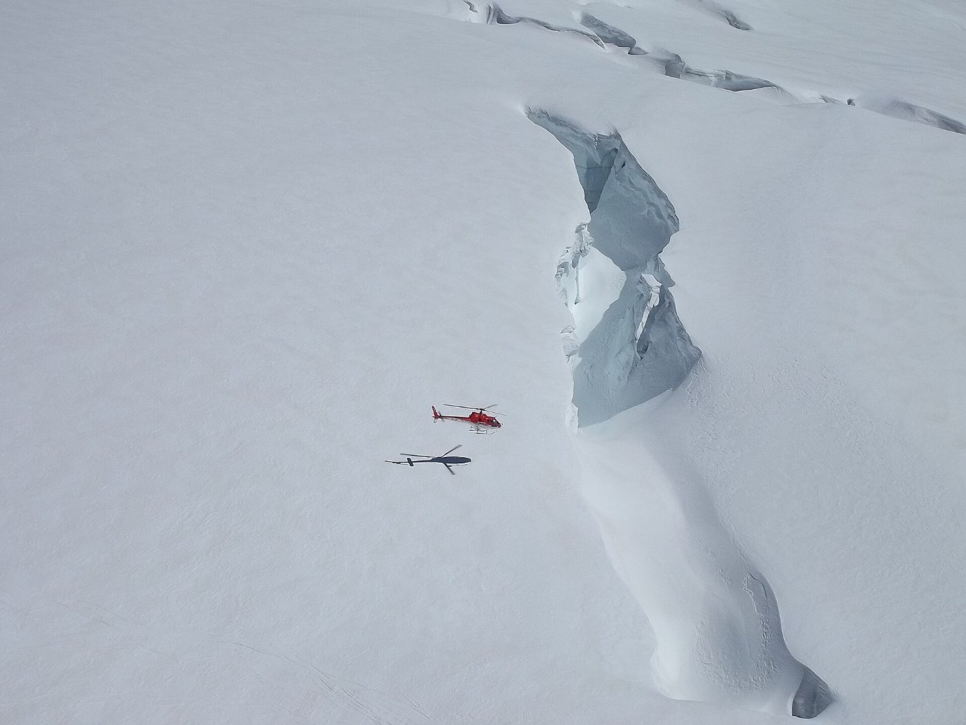 Helicopter next to a crevasse on the Jungfraujoch