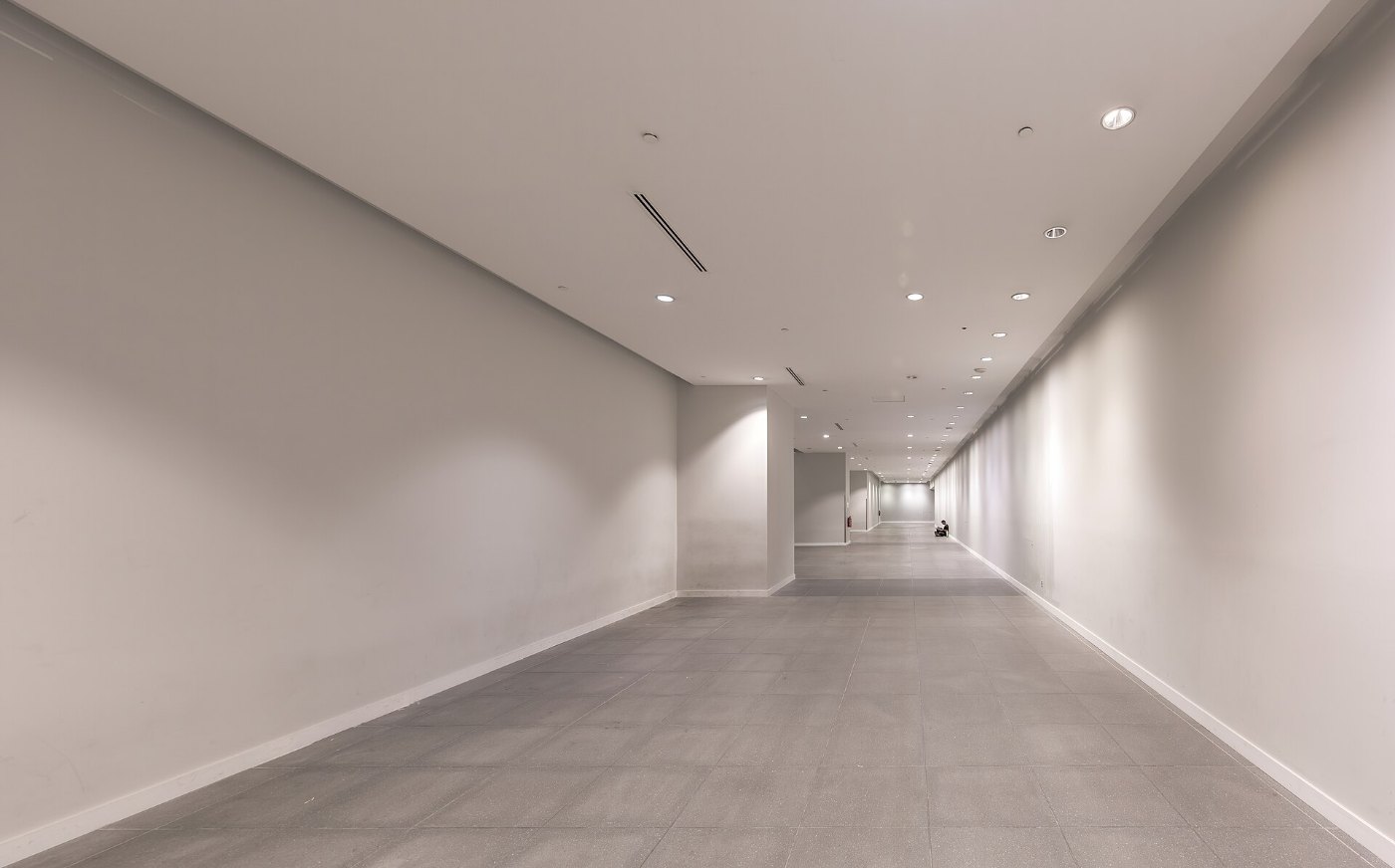 Long corridor with someone sitting on the floor in the distance at Marin